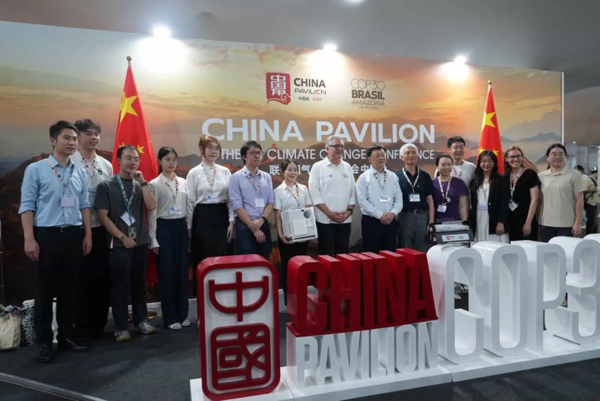 ベレンのCOP30で、中国パビリオンの展示の前で撮影した集合写真。